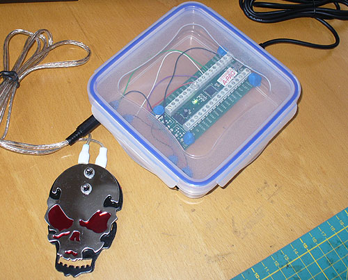 Image of a DIY Assistive Technology Lunch Box Interface, pictured with a DIY skull pedal.