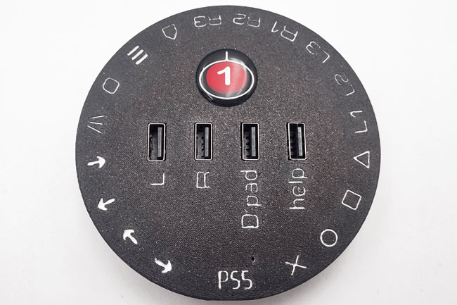 Round CATCH 22 interface in black, with white PS5 labelling for each switch and USB socket.