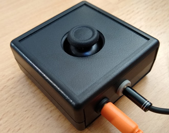 Xbox Adaptive Controller (XAC) mini joystick accessory from OneSwitch. Small black thumb-stick in a box. Lightweight, sensitive, light pressure.