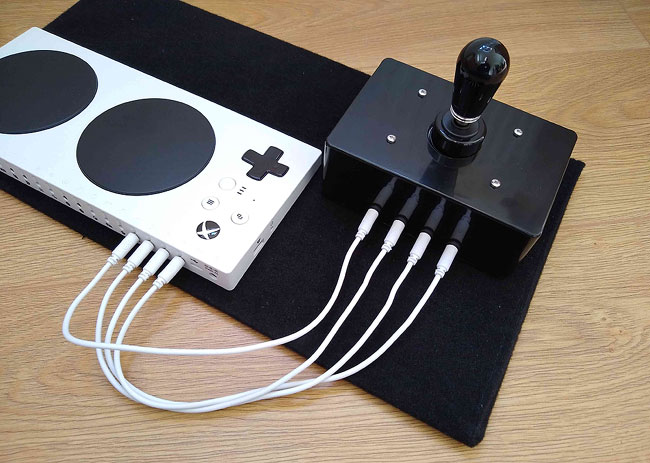 Rear of 4 Switches Joystick and Xbox adaptive Controller, with four short white patch cables linking the joystick to the XAC d-pad sockets.