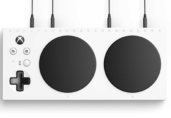 Xbox Adaptive Controller: Image of white rectagular thin controller with black controls and switch cables patched into the back sockets.