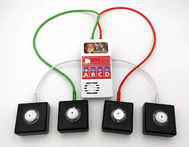 Truman Toys Audio Adventure console, switch adapted by OneSwitch with four round push-buttons in black square boxes underneath. All connected with bright cables.