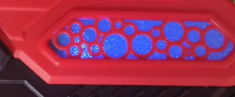 Blue illuminated sparkly panel on side of water pistol.