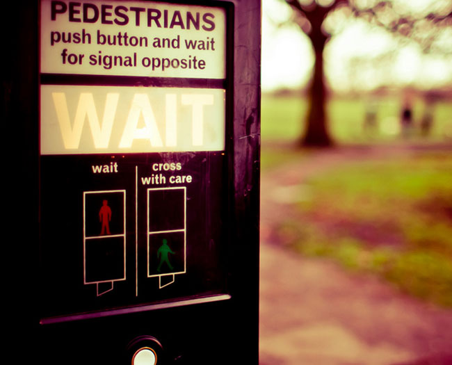 One Switch 100. Image of a UK Pedestrian Crossing control box, with three blurry people in the distance.