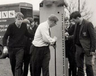 Nellie arrives, with a teacher and school boys pulling a huge computer along on a trolly.